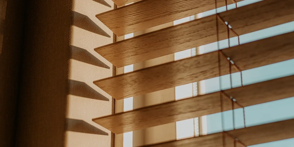 Afternoon sun filtering through lowered wooden blinds
